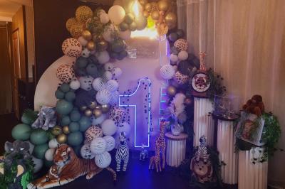 Terrasse en bois avec fauteuils, pergola à rideaux blancs, plantes en pot et mur en briques en arrière-plan.