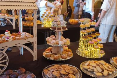 Terrasse en bois avec fauteuils, pergola à rideaux blancs, plantes en pot et mur en briques en arrière-plan.