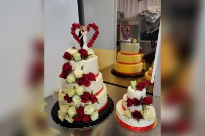 Terrasse en bois avec fauteuils, pergola à rideaux blancs, plantes en pot et mur en briques en arrière-plan.