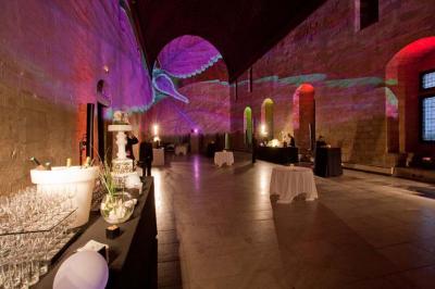 Vue nocturne d'un jardin avec des invités rassemblés lors d'un événement, éclairé par des lumières chaleureuses.