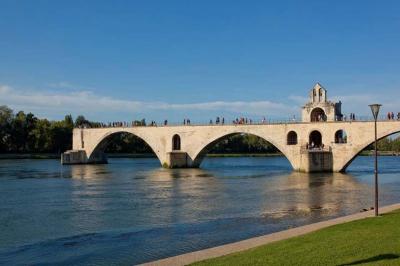 Vue nocturne d'un jardin avec des invités rassemblés lors d'un événement, éclairé par des lumières chaleureuses.
