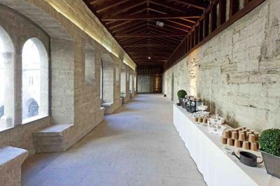 Vue nocturne d'un jardin avec des invités rassemblés lors d'un événement, éclairé par des lumières chaleureuses.