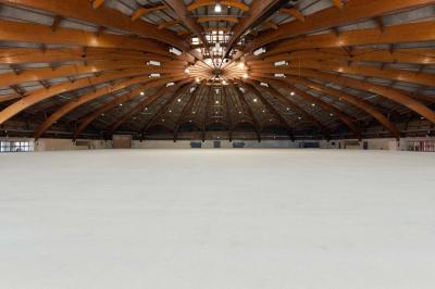 Vue nocturne d'un jardin avec des invités rassemblés lors d'un événement, éclairé par des lumières chaleureuses.