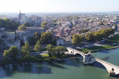Vue nocturne d'un jardin avec des invités rassemblés lors d'un événement, éclairé par des lumières chaleureuses.