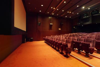 Espace intérieur moderne avec canapés colorés, éclairage suspendu et logo ’TUMO Paris’ sur un mur noir.