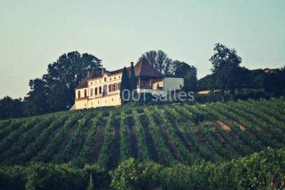 Façade d'une maison ancienne avec volets en bois, entourée de végétation sous un ciel dégagé.