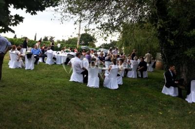 Façade d'une maison ancienne avec volets en bois, entourée de végétation sous un ciel dégagé.