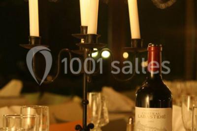 Façade d'une maison ancienne avec volets en bois, entourée de végétation sous un ciel dégagé.