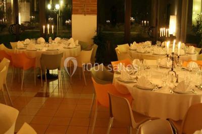 Façade d'une maison ancienne avec volets en bois, entourée de végétation sous un ciel dégagé.