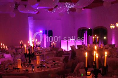 Façade d'une maison ancienne avec volets en bois, entourée de végétation sous un ciel dégagé.