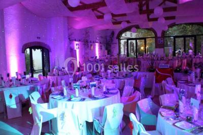 Façade d'une maison ancienne avec volets en bois, entourée de végétation sous un ciel dégagé.