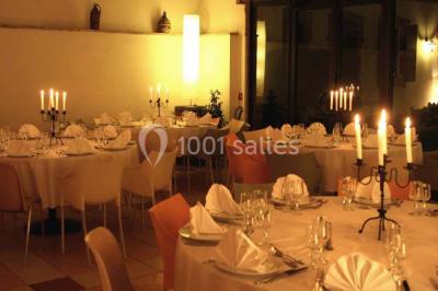 Façade d'une maison ancienne avec volets en bois, entourée de végétation sous un ciel dégagé.
