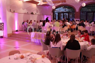 Façade d'une maison ancienne avec volets en bois, entourée de végétation sous un ciel dégagé.