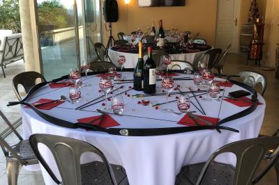 Champ d'oliviers verdoyants sous un ciel clair, entouré de collines et de végétation méditerranéenne.