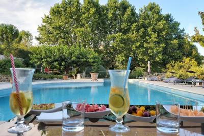 Vue sur un jardin verdoyant avec des arbres et des collines en arrière-plan sous un ciel dégagé.
