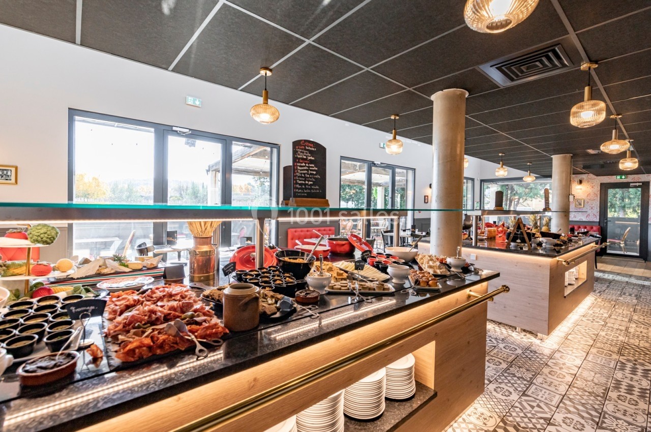 Buffet varié avec plats salés et sucrés disposés sur un comptoir dans un restaurant lumineux.