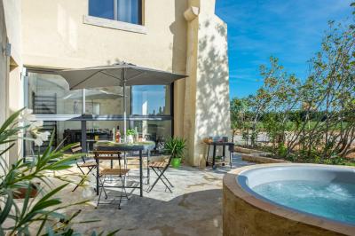 Chambre lumineuse avec lit double, fauteuil beige, fenêtre ouverte sur un paysage et décoration murale en osier.