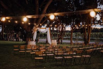 Chambre lumineuse avec lit double, fauteuil beige, fenêtre ouverte sur un paysage et décoration murale en osier.