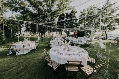 Chambre lumineuse avec lit double, fauteuil beige, fenêtre ouverte sur un paysage et décoration murale en osier.