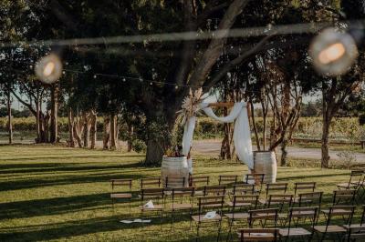 Chambre lumineuse avec lit double, fauteuil beige, fenêtre ouverte sur un paysage et décoration murale en osier.