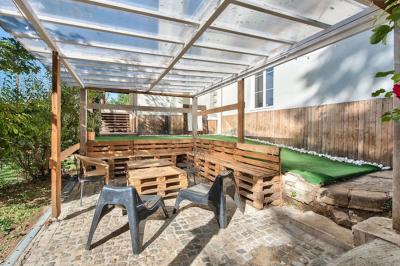 Groupe de personnes discutant et partageant un moment convivial en extérieur, éclairé par une lumière nocturne.