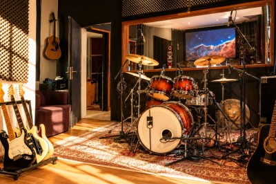 Salle sombre avec éclairage rouge et bleu, une estrade avec équipement audio et un tapis mural en arrière-plan.