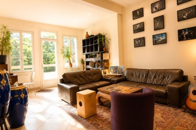 Salle sombre avec éclairage rouge et bleu, une estrade avec équipement audio et un tapis mural en arrière-plan.