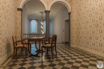 Piscine rectangulaire entourée de dalles et pelouse, avec un grand arbre en arrière-plan sous un ciel dégagé.