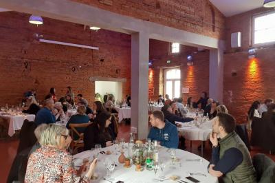 Piscine rectangulaire entourée de dalles et pelouse, avec un grand arbre en arrière-plan sous un ciel dégagé.