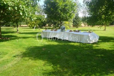 Vue aérienne d'un domaine rural avec bâtiments en pierre, cour centrale, champs, étang et arbres environnants.