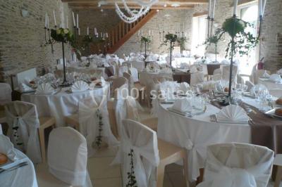 Vue aérienne d'un domaine rural avec bâtiments en pierre, cour centrale, champs, étang et arbres environnants.