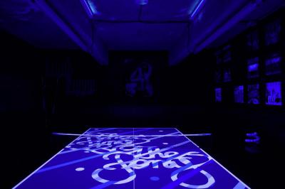 Tranches de pain garnies de légumes grillés, fromage et feuilles de basilic, présentées sur une planche en bois.