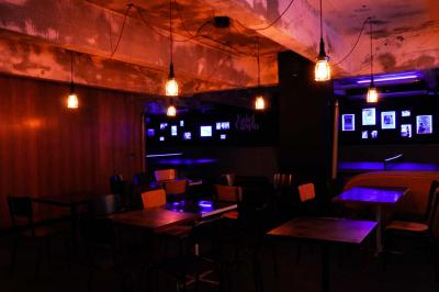 Tranches de pain garnies de légumes grillés, fromage et feuilles de basilic, présentées sur une planche en bois.