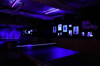 Tranches de pain garnies de légumes grillés, fromage et feuilles de basilic, présentées sur une planche en bois.