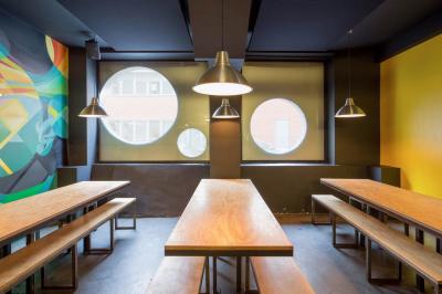 Tranches de pain garnies de légumes grillés, fromage et feuilles de basilic, présentées sur une planche en bois.