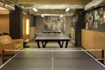 Tranches de pain garnies de légumes grillés, fromage et feuilles de basilic, présentées sur une planche en bois.