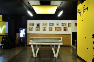 Tranches de pain garnies de légumes grillés, fromage et feuilles de basilic, présentées sur une planche en bois.