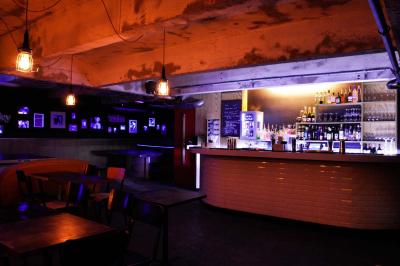 Tranches de pain garnies de légumes grillés, fromage et feuilles de basilic, présentées sur une planche en bois.