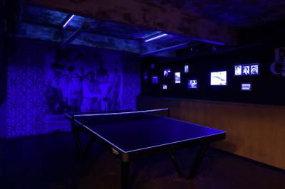 Tranches de pain garnies de légumes grillés, fromage et feuilles de basilic, présentées sur une planche en bois.