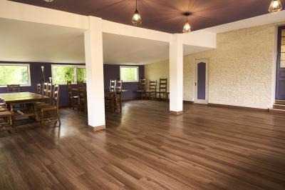 Salle de réception décorée pour un événement, avec tables rondes dressées et un écran de projection allumé.