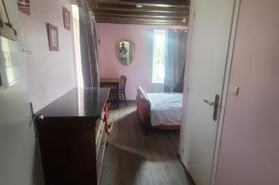 Salle de réception décorée pour un événement, avec tables rondes dressées et un écran de projection allumé.