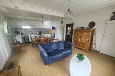 Salle de réception décorée pour un événement, avec tables rondes dressées et un écran de projection allumé.