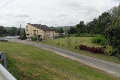 Salle de réception décorée pour un événement, avec tables rondes dressées et un écran de projection allumé.