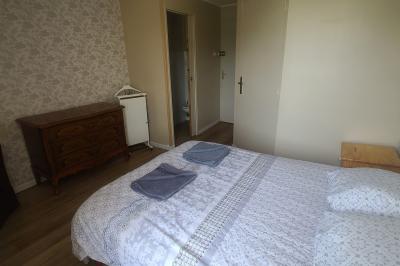 Salle de réception décorée pour un événement, avec tables rondes dressées et un écran de projection allumé.