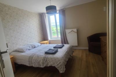 Salle de réception décorée pour un événement, avec tables rondes dressées et un écran de projection allumé.