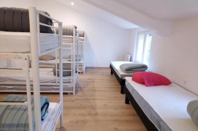 Salle de réception décorée pour un événement, avec tables rondes dressées et un écran de projection allumé.