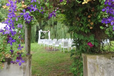 Salle de réception décorée pour un événement, avec tables rondes dressées et un écran de projection allumé.
