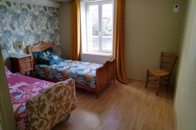 Salle de réception décorée pour un événement, avec tables rondes dressées et un écran de projection allumé.