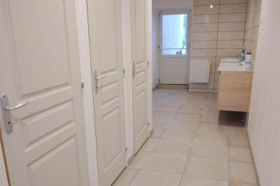 Salle de réception décorée pour un événement, avec tables rondes dressées et un écran de projection allumé.