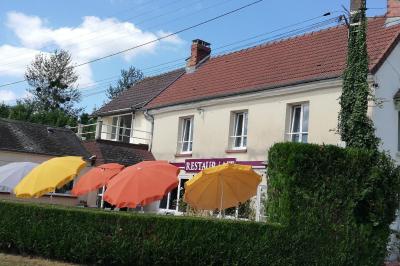 Salle de réception décorée pour un événement, avec tables rondes dressées et un écran de projection allumé.